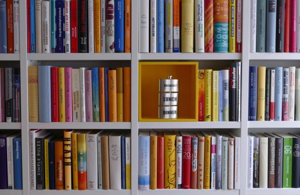 istock Filled books shelves and one part empty presenting hip flask 909115362
