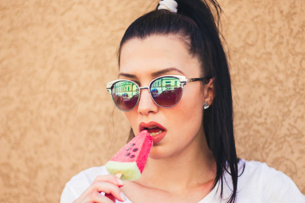 istock young woman with watermelon ice cream. 909118446