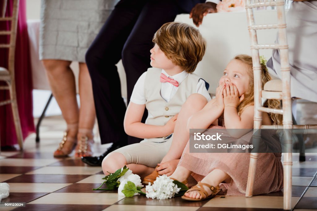 Children Watching at a Wedding Children are sitting on the dancefloor by a table at a wedding. They are watching the bride and groom share their first dance. Wedding Stock Photo