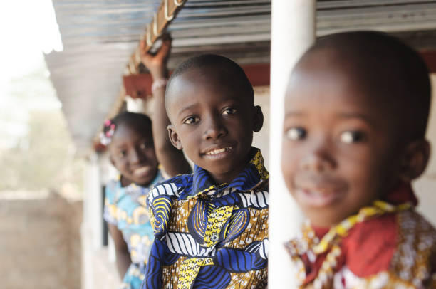 three african children smiling and laughing outdoors - áfrica ocidental imagens e fotografias de stock