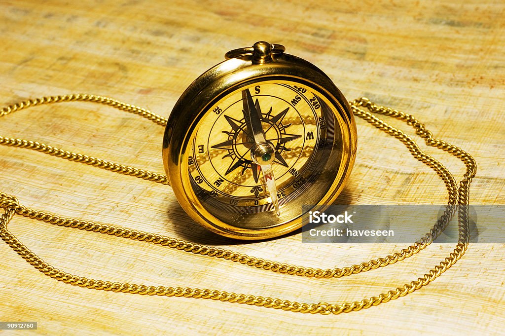 Old style gold compass on papyrus background  Navigational Compass Stock Photo