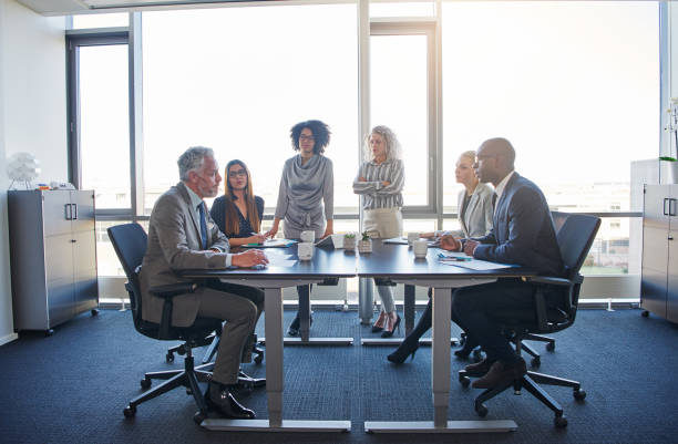 istock Businesspeople talking around a table in a modern office 909135510