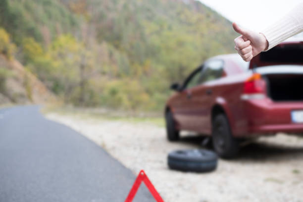man helping for woman to change broken wheel