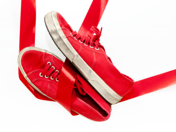 Red shoes, a symbol femicide. Illustrative editorial The model of red shoes for women, casual shoes on a white floor and joined by a red ribbon, which is the common thread that unites them: violence against women, symbolized by red shoes. blow up doll stock pictures, royalty-free photos & images