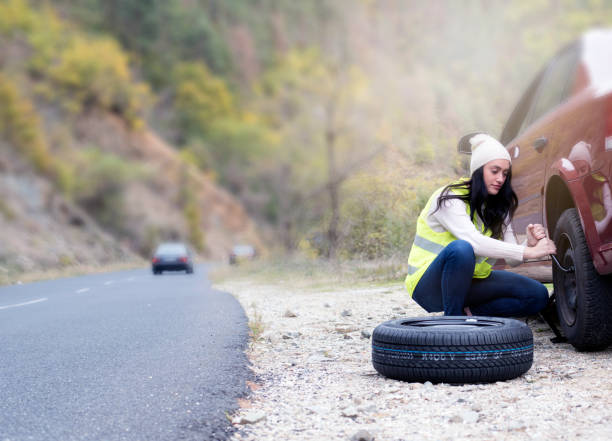 istock Young Women Changing A Flat Tire 909145484