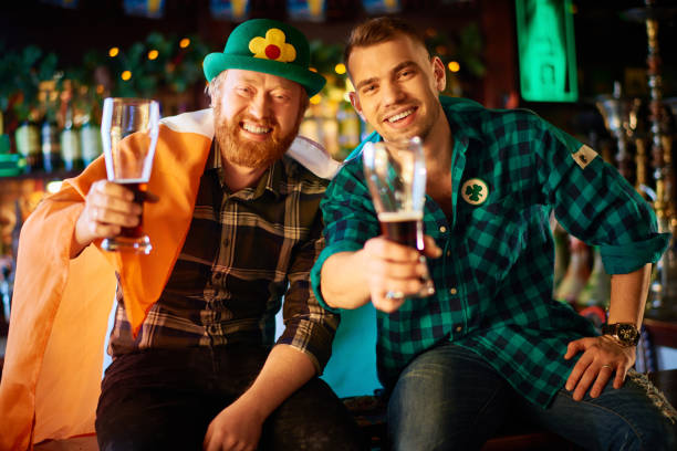 istock Happy men in Irish costumes relaxing with beer 909149876