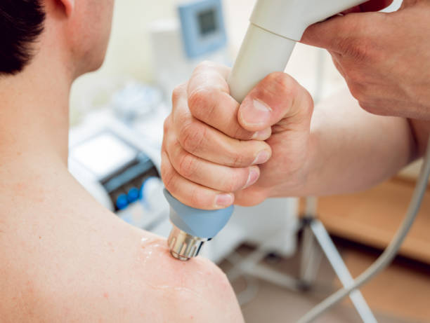 istock Shock wave therapy. The magnetic field, rehabilitation. Physiotherapist doctor performs surgery on a patient's shoulder 909150628