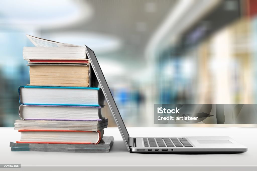 Education. Stack of books with laptop on wooden table Book Stock Photo