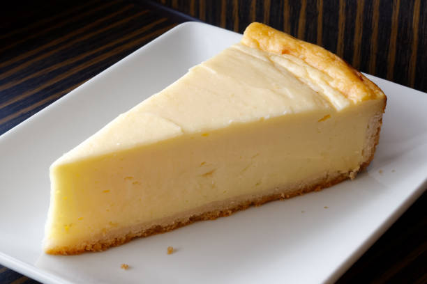 istock A slice of plain baked cheesecake on white ceramic plate. Dark background. 909158072