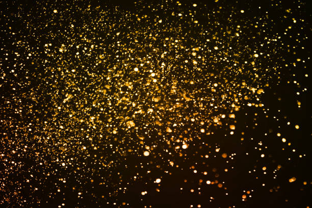 istock christmas gold sparkle glitter explosion dust particles background with bokeh, gold holiday happy new year and valentine day 909158108