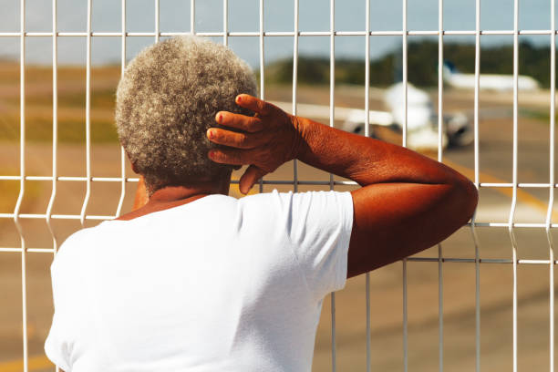 femme âgée afro-américaine ressemble à l’avion au décollage à l’aéroport de salvador, brésil - mesh netting metal black photos et images de collection