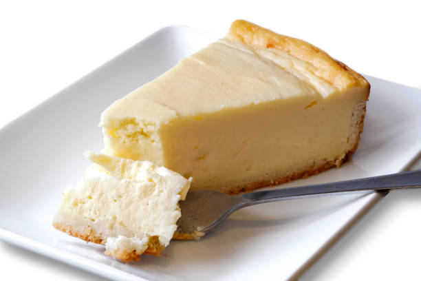 istock Plain baked cheesecake with cake on fork on white ceramic plate. White background. 909158860