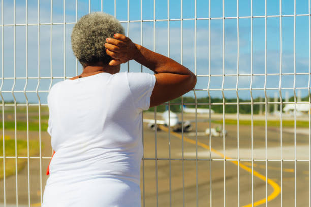 femme âgée afro-américaine ressemble à l’avion au décollage à l’aéroport de salvador, brésil - mesh netting metal black photos et images de collection