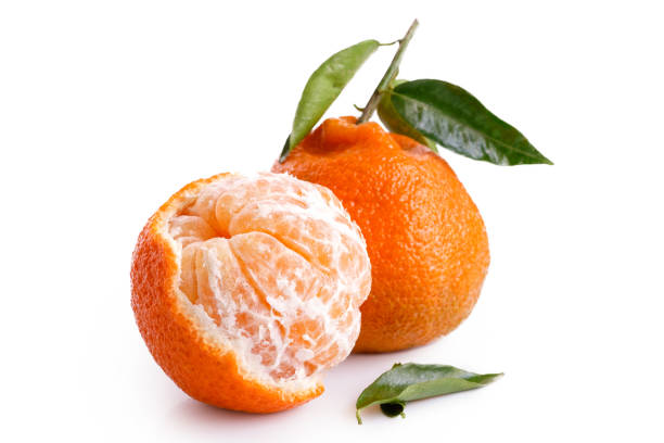 istock One half peeled and one whole mandarin with leaves isolated on white. 909163948