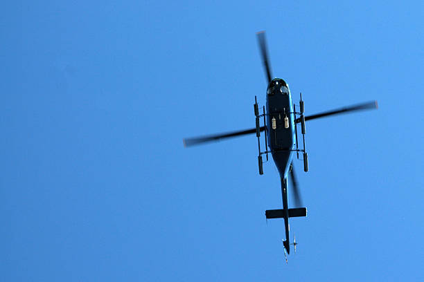 istock helicopter silhouette Bell 407 flying in blue sky 90917103