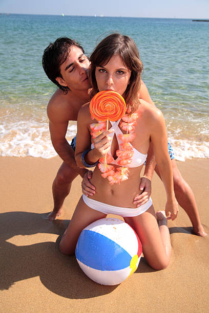 sedução. - swimming trunks women beach ball couple - fotografias e filmes do acervo