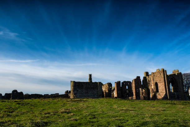 Lindisfarne priory on Holy Island in Northumberland Strong sunlight on the Holy Island of Lindisfarne plays across the priory buildings, established after the Viking raids lindisfarne monastery stock pictures, royalty-free photos & images