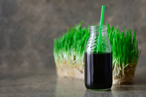 frisch gepresster weizengras teil in einer flasche mit einem strohhalm - wheatgrass nutritional supplement antioxidant grass stock-fotos und bilder