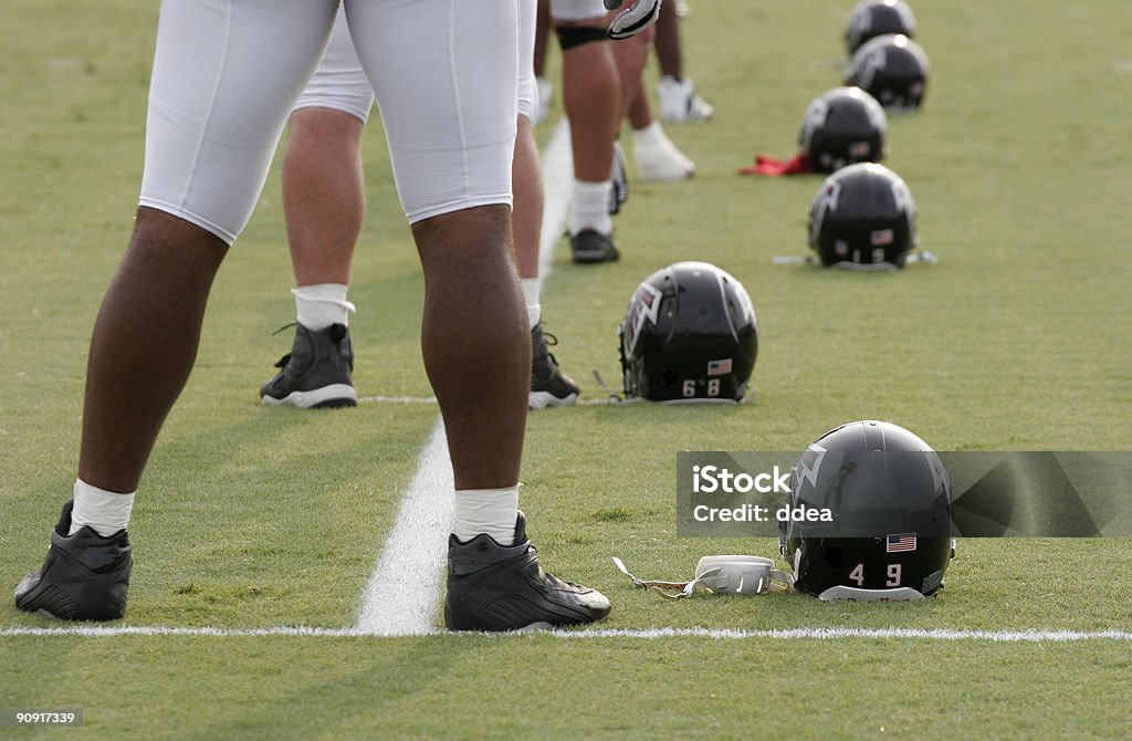 Row of Football Players with Helmets on Ground  American Culture Stock Photo