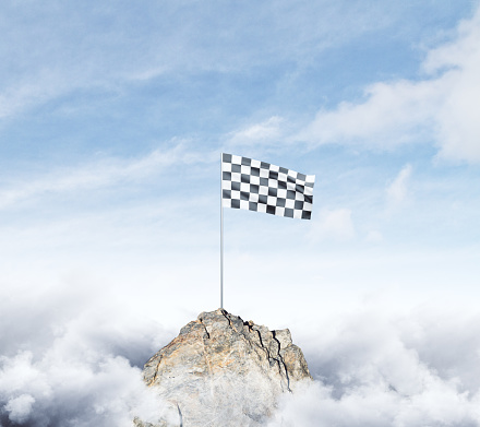 Checkered flag on mountain top. Cloudy sky background. Achievement concept