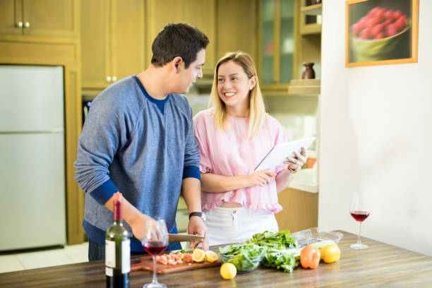 istock Couple in kitchen preparing food 909184350