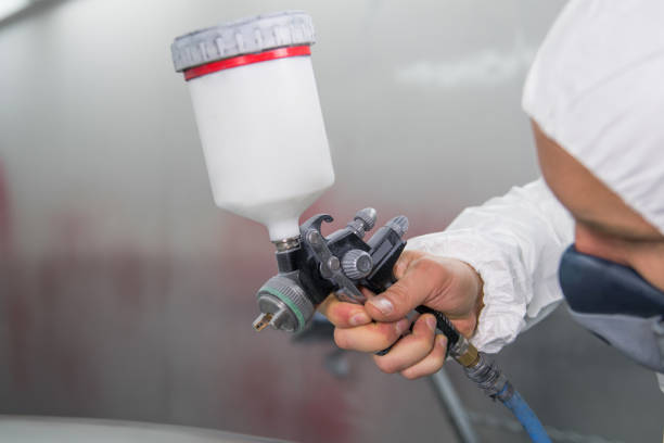 istock Painter spray gun in the hands of a painter. 909190738