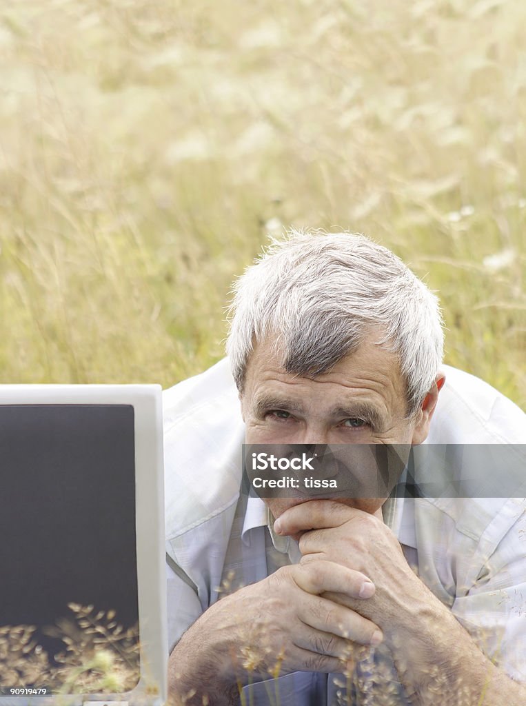 Uomo anziano con il computer portatile - Foto stock royalty-free di Adulto