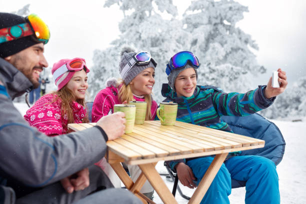 istock Boy making selfie with family in cafe on ski terrain 909197302