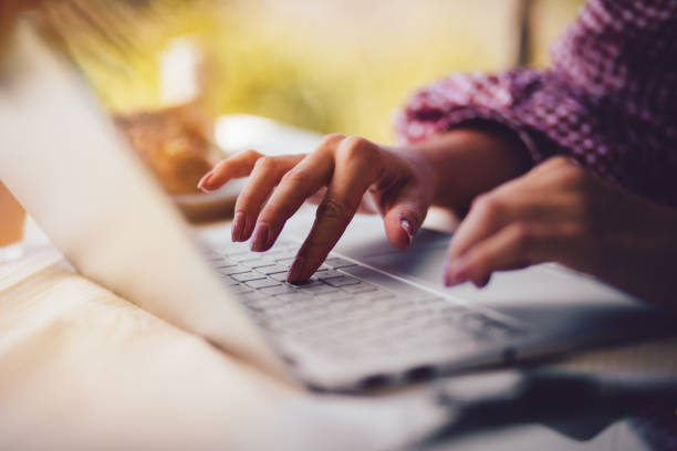 close-up of woman's hands typing on laptop keyboard - rural watch imagens e fotografias de stock