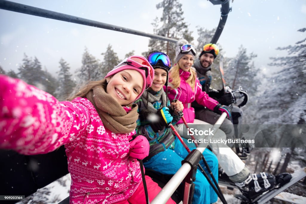 Happy family in cable car climb to ski terrain Happy family with children in cable car climb to ski terrain Family Stock Photo