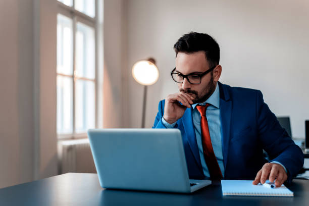 istock Thoughtful businessman in office working on laptop. 909203328