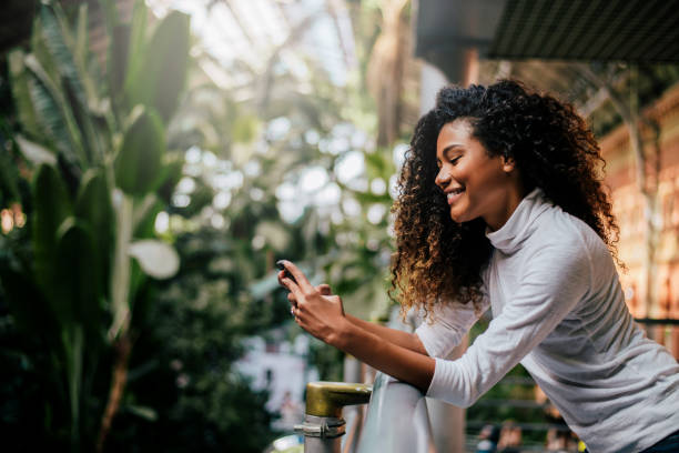 istock Side view of beautiful woman using her phone indoors. 909203600