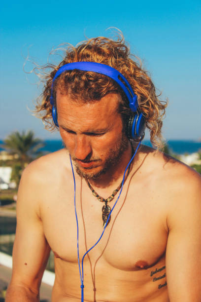 istock Men listening to podcast and sunbathing 909204514