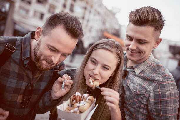istock Smiling Friends Sharing Donuts and Having a Great Time 909207248