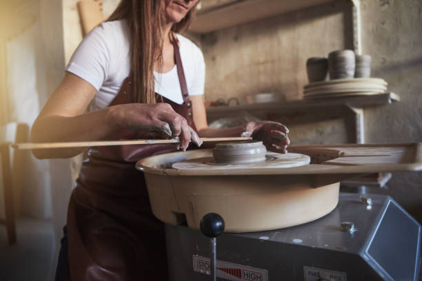 istock Creative artisan measuring a turning vase in her workshop 909207904