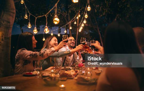 Friends Toasting With Wine And Beer At Rustic Dinner Party Stock Photo - Download Image Now