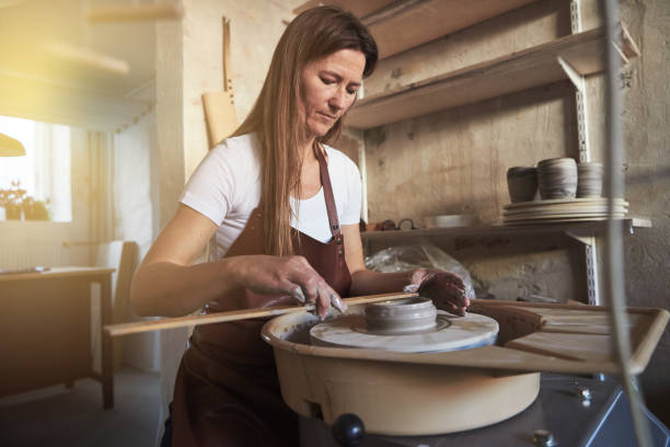 istock Artisan taking measurements while turning clay on a pottery wheel 909208282