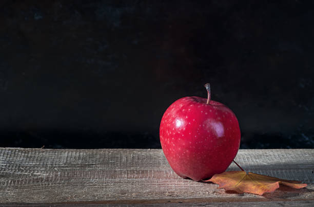 istock Red ripe apple on a wooden table 909214398