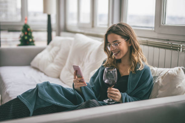 vrouw met behulp van mobiele telefoon - drinking wine stockfoto's en -beelden