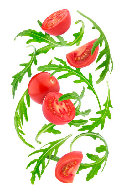 spadające świeże warzywa. pomidory cherry i rucola wyizolowane na białym tle - cherry tomato tomato sauce isolated close up zdjęcia i obrazy z banku zdjęć