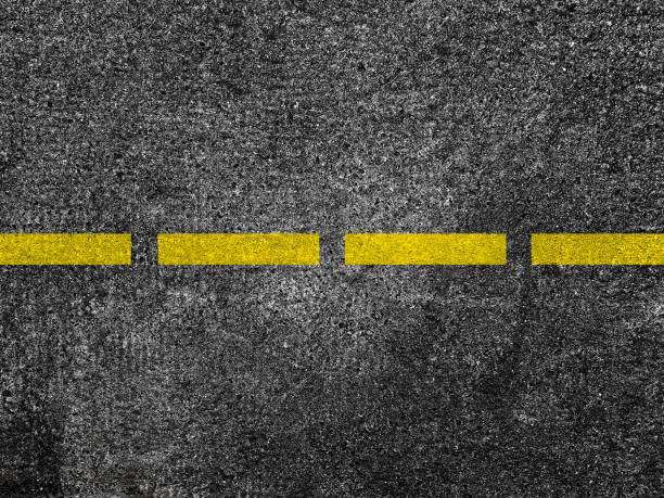 istock Yellow line on asphalt road background 909230502