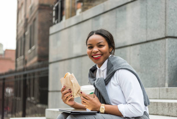 istock Businesswoman eating  sandwich and using digital tablet 909232176