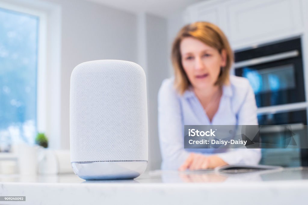 Woman In Kitchen Asking Digital Assistant Question Virtual Assistant Stock Photo