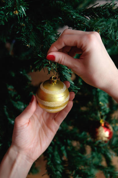 istock hands of woman decorating christmas tree 909240134