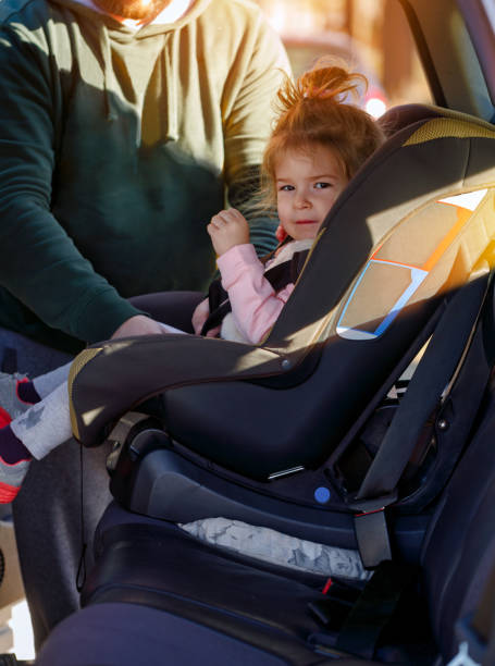 istock Father fastening security belt to child in car 909240526