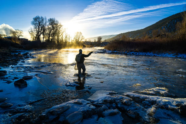 pescatore di mosca pesca invernale - winter river foto e immagini stock