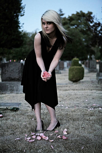 istock Blonde Stooping with Rose Petals in a Cemetery 90924690