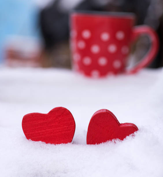 istock two wooden red hearts on the snow 909254606