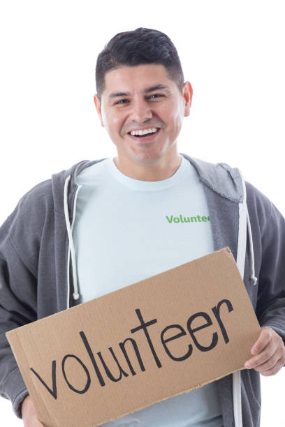istock Cheerful man with 'volunteer' sign 909258144
