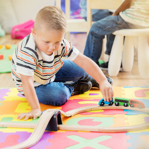 istock Preschooler plays with trains at school 909258590